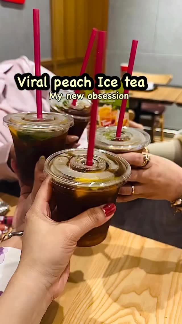 Hands raising iced teas around a restaurant table